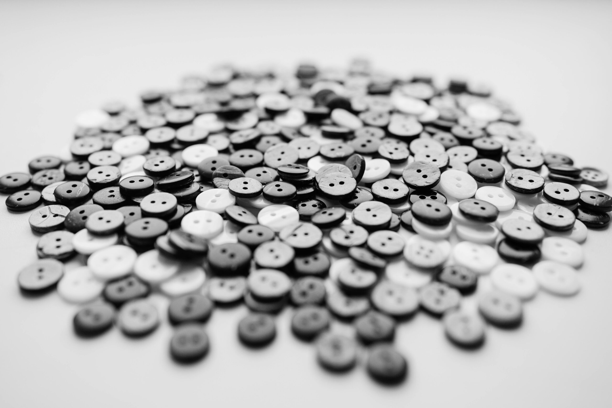 Close-up of a collection of black and white buttons in a still life composition.